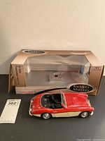 Model car displayed in front of original Grandes Marques box and auction lot card