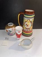 All four items grouped: beer stein, round vase, bud vase, creamer
