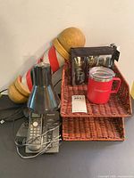 Group shot showing cordless phone, barber pole, lamp, wicker trays, travel kit, red mug