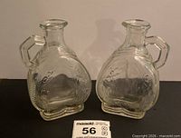 Front view of both Hornes clear glass decanters showing overall shape, relief design and condition