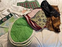Stack of green and pink quilted placemats, multiple table runners layered
