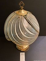 Top view of brass table lamp showing frosted glass globe shade with etched swirl pattern