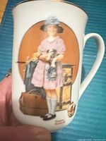 Front view of mug showing illustration, gold rim and handle profile