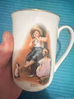 Front of mug showing Norman Rockwell image and gold rim