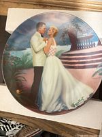 Front view of porcelain plate showing romantic scene and artist signature
