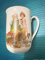 Front of porcelain mug showing Norman Rockwell illustration and artist signature