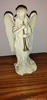 Front view of ivory angel figurine with trumpet