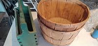 Nested wooden bushel baskets beside green wooden tote