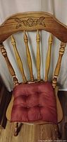 Side chair front view with red cushion showing carved crest and spindles