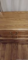 Top and upper drawers showing maple surface and brass pulls