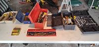 Tabletop view of six tool containers with mixed contents