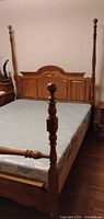 Full view of assembled queen four-poster bed frame with mattress