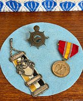 Group shot of shatlen, cap badge, medal on blue circle