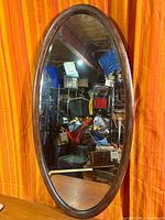 Front view of oval mirror showing oak frame and glass