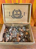 Open Rosa del Rancho cigar box filled with pennies