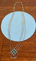 Full view of multi-strand sterling silver necklace with turquoise pendant