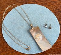 Full view of sterling chain, rectangular mabe pearl pendant, and pair of black pearl studs