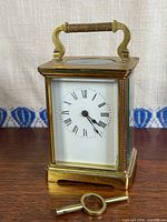Front view of brass carriage clock and key
