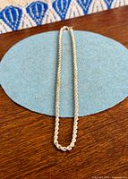 Entire rope chain laid flat on blue surface