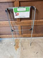 Front view of metal Bag Buddy frame with label attached