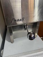 Front view showing Arnett logo and dispensing lever