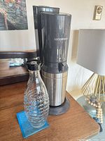 Front view of SodaStream soda maker with glass carafe
