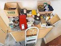 overview of table with fasteners, discs, finishes, gloves, step ladder