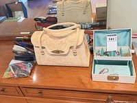 Overall lot showing handbag, jewelry box open, hair brushes, combs, umbrellas, hair accessories