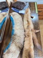 Two stoles and dark brown fur piece on table