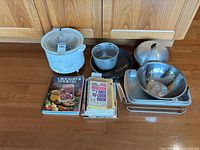 Group shot of slow cooker, cookware, trays and cookbooks