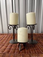 three candle holders each with accompanying pillar candle displayed