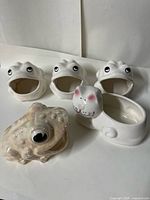 Group shot of three matching frog planters, one cat planter, one iridescent toad planter