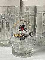 Front view of Holsten Bier glass mug showing logo and faceted design