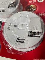 Close view of Kidde smoke alarm showing Hush/test buttons and battery compartment