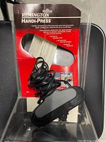 Full view of Remington Handi-Press in original packaging with coiled cord visible