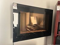 Front view of black glass electric fireplace on wall