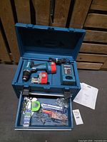 Open Makita case showing drill, batteries, charger, bit drawer