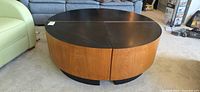 Four assembled wedge tables forming complete round coffee table, wood veneer sides visible