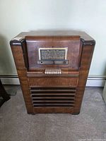 Full frontal view of Rogers floor console tube radio showing wood cabinet and slatted speaker grill