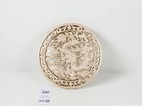 Front view of round carved wood dragon panel