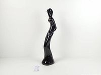 Full view of tall glossy black ceramic female figure sculpture