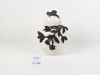 Full view of ginger jar showing white glaze and black raised foliage