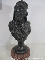 Full view of bronze bust on wood base