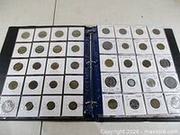 Binder open showing two filled 20-pocket pages of 2×2 coin holders