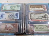 binder open showing Philippine notes and Japanese Government, U.S. note