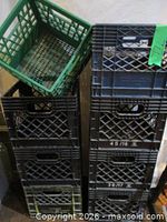 Stacked black crates with green crate perched on top