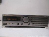 Front view of JVC RX-509V receiver showing display, volume knob, and controls