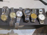 Group shot of all six wrist watches on black stand