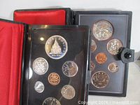 Both coin sets in their original cases, coins visible