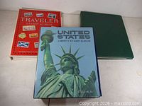Cover view of three stamp albums: red Traveler, blue United States Liberty, green binder